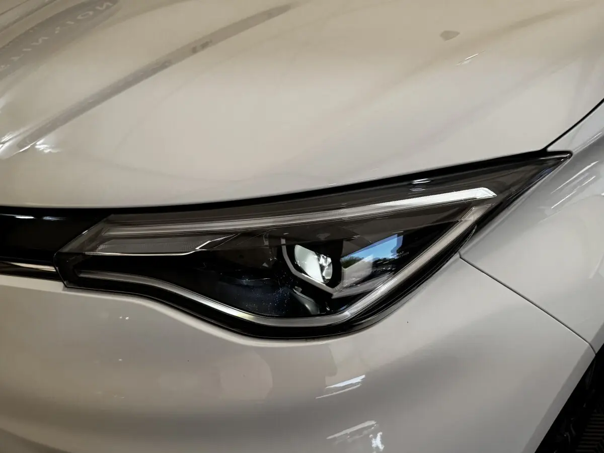 Gros plan sur le phare avant droit blanc d'une Renault ZOE Iconic R135 électrique de 2022.
