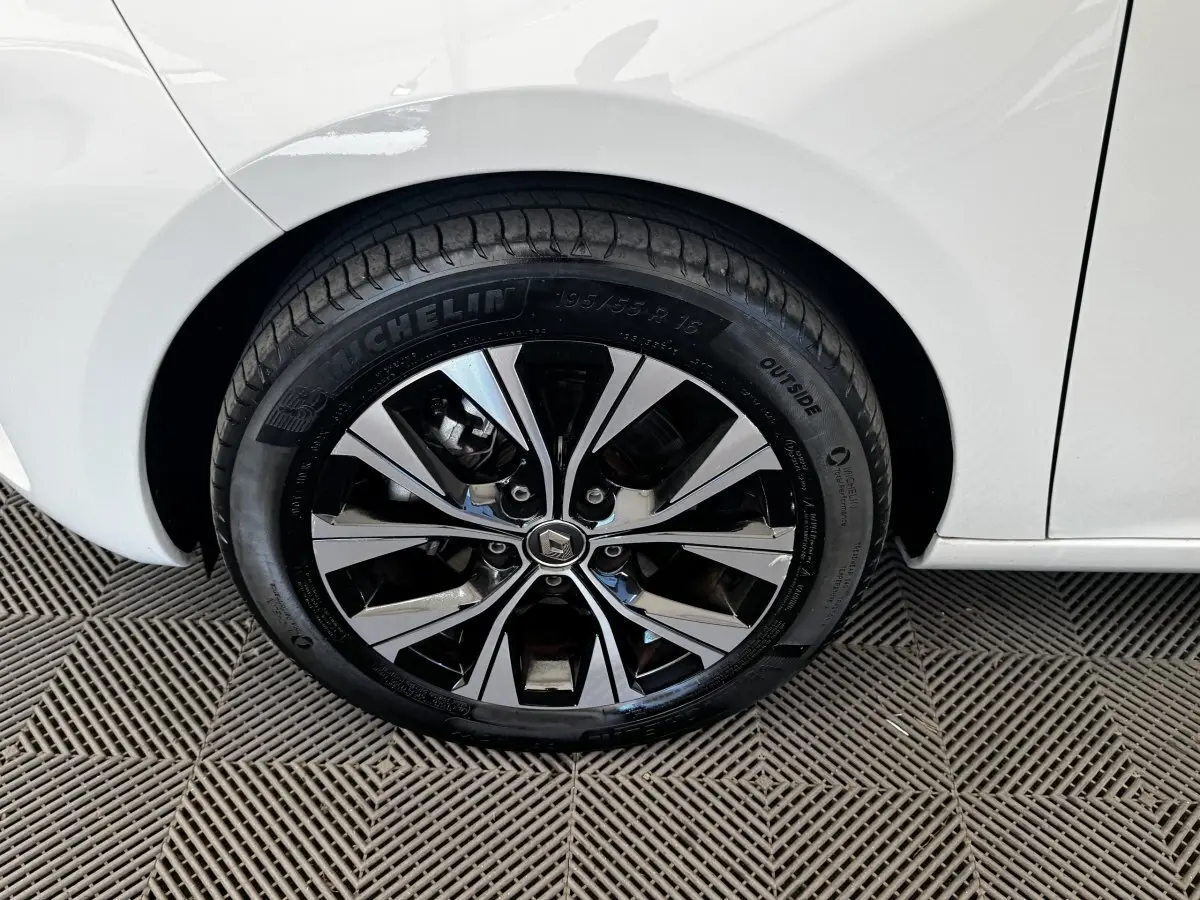 Gros plan sur la roue arrière droite d'une Renault ZOE blanche, mettant en valeur la jante alliage bicolore et le pneu Michelin.