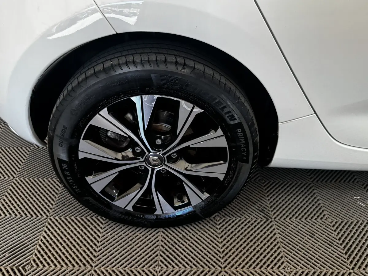 Gros plan sur la roue arrière droite blanche de la Renault ZOE Iconic R135 avec jante alliage noire et argentée.