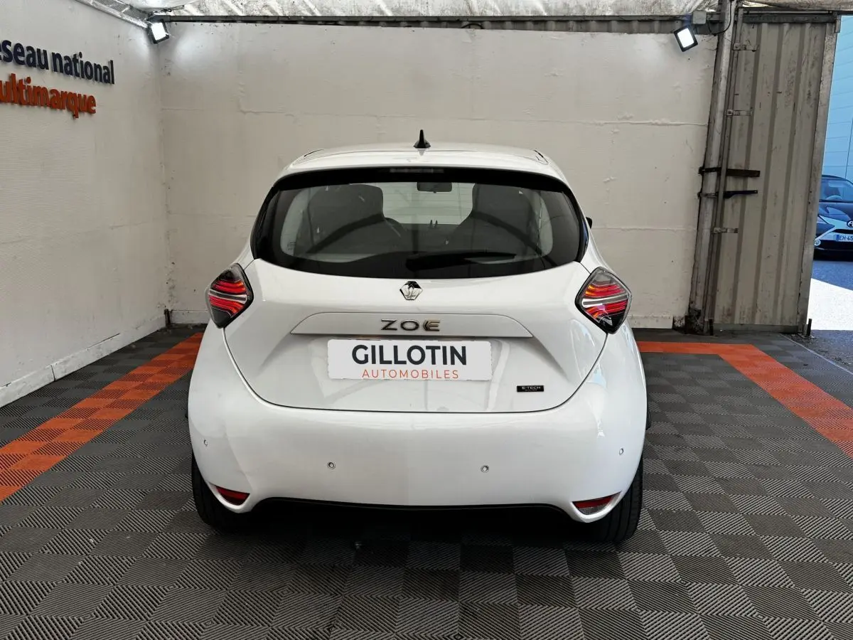 Vue arrière d'une Renault ZOE blanche Iconic R135 2022, avec feux arrière LED et logo distinctif au centre.