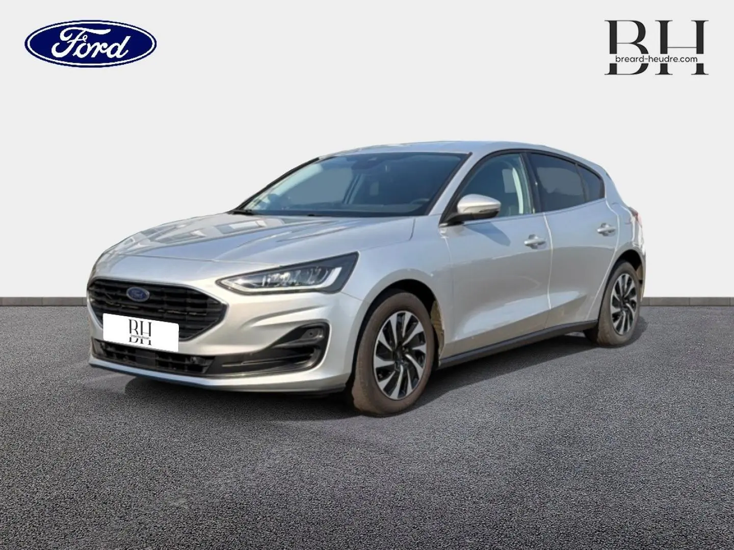 Ford Focus 2023 gris lunaire métallisé vue 3/4 avant avec calandre noire et jantes alliage bicolores.