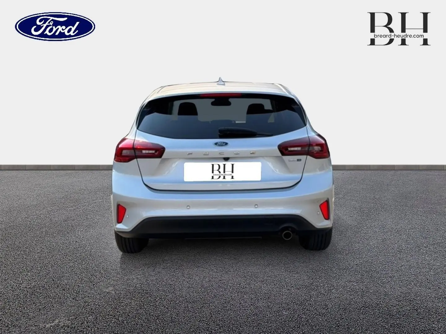 Vue arrière d'une Ford Focus 2023 gris lunaire métallisé avec feux LED et échappement chromé visible.