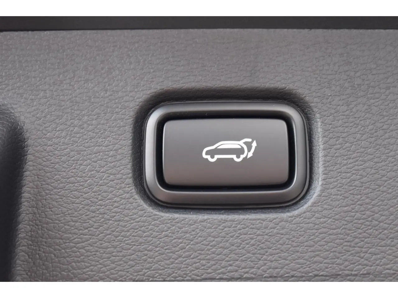 Bouton noir d'ouverture électrique du hayon sur tableau de bord du Kia Sportage hybride noir 2026.