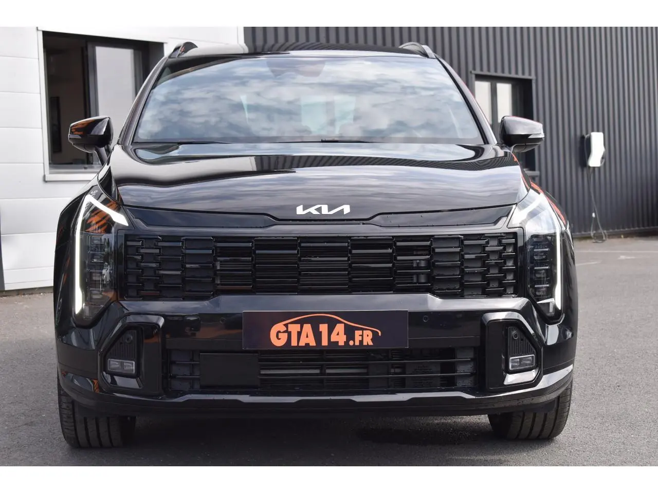 Vue frontale du KIA Sportage noir 2026 avec calandre noire et phares LED verticaux distinctifs.