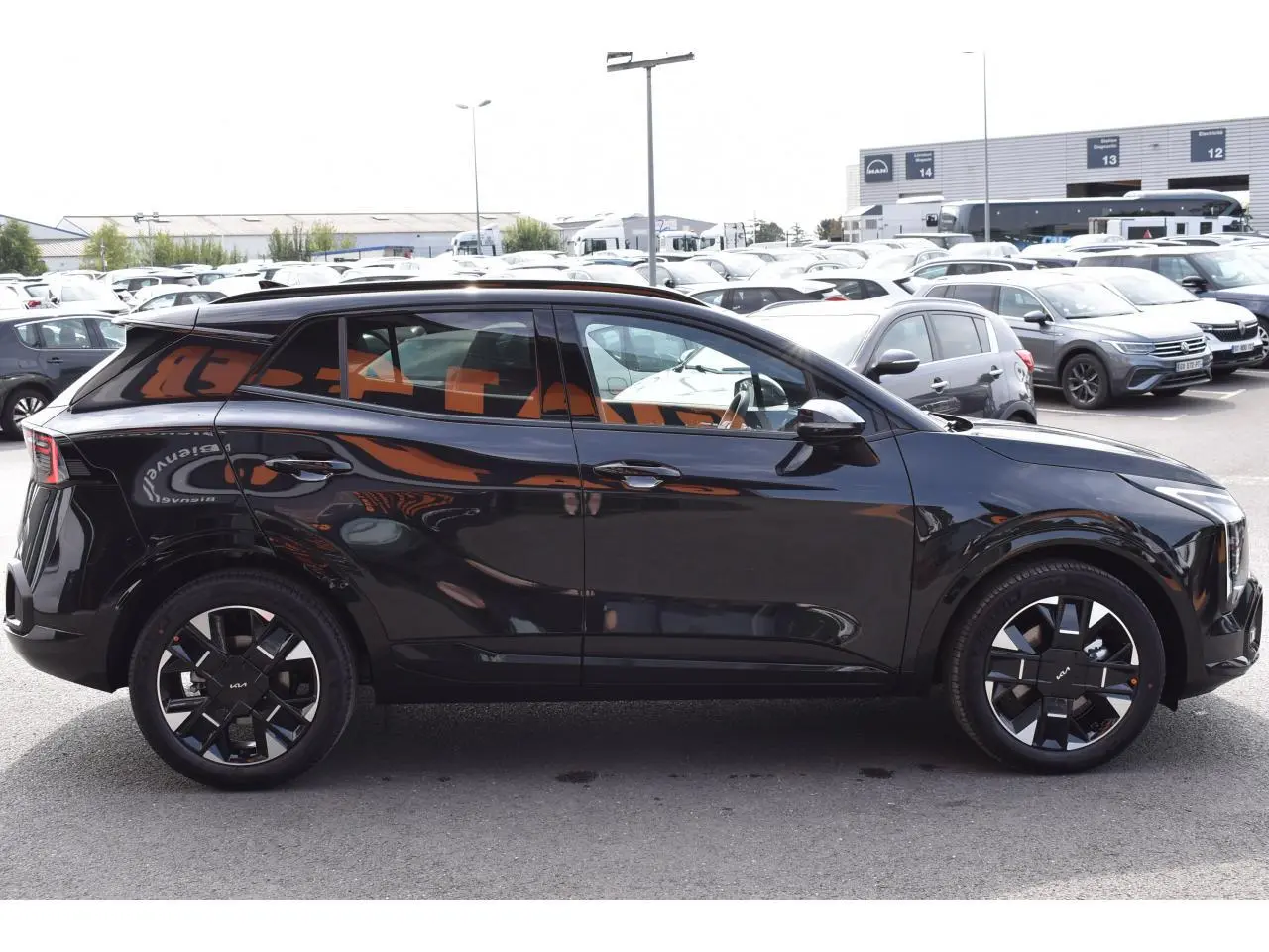 KIA SPORTAGE hybride noir vu de profil côté gauche, avec jantes 19 pouces et vitres surteintées.
