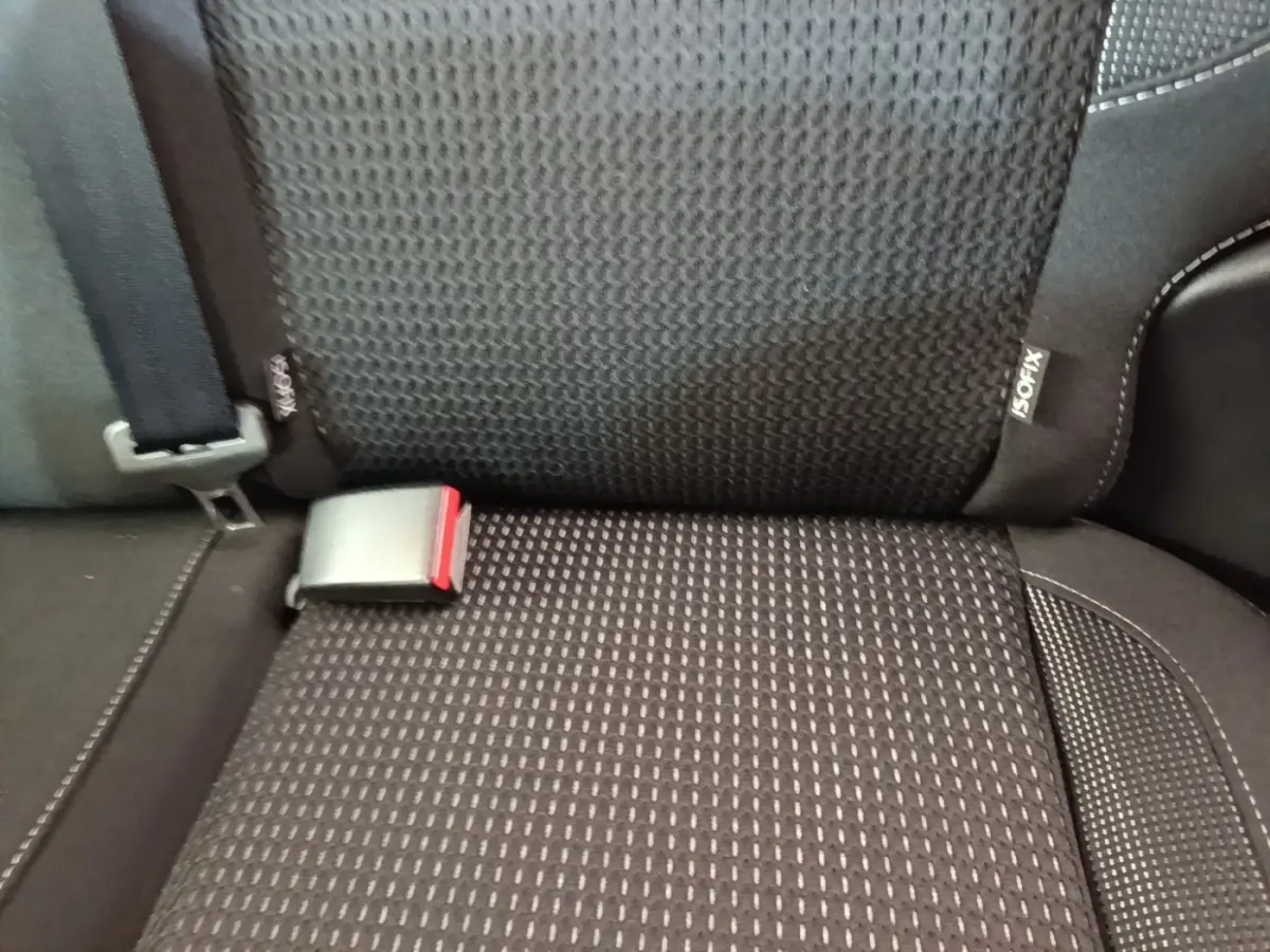 Gros plan sur la banquette arrière noire de la Peugeot 208 Puretech 82 Allure avec ceinture et étiquette ISOFIX visible.
