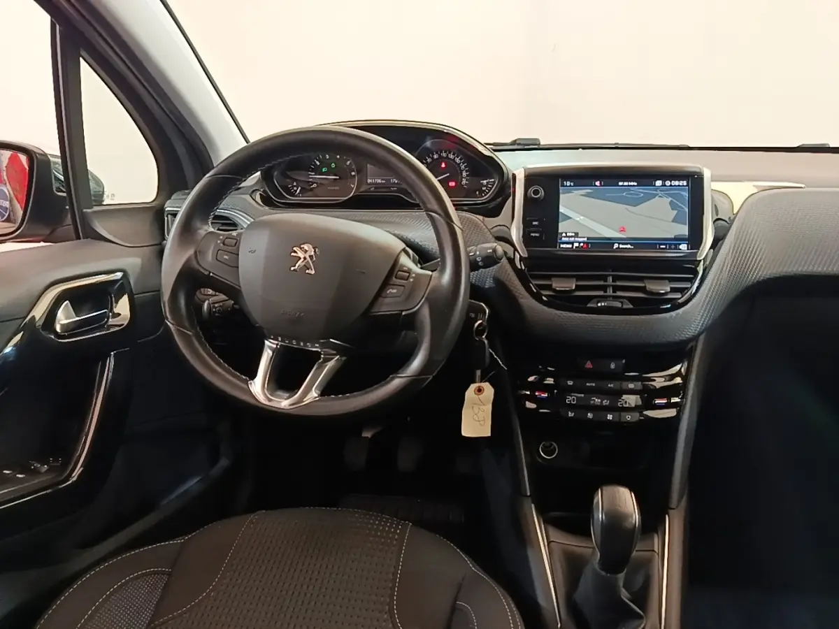 Vue intérieure avant de la Peugeot 208 Puretech 82 Allure 2019, tableau de bord noir avec écran tactile de navigation.