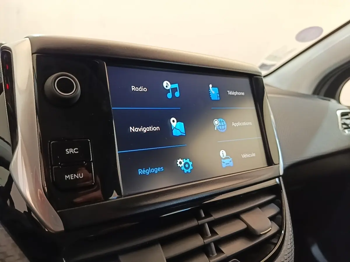 Gros plan sur l'écran tactile central du tableau de bord de la Peugeot 208 Puretech 82 Allure, intérieur noir.