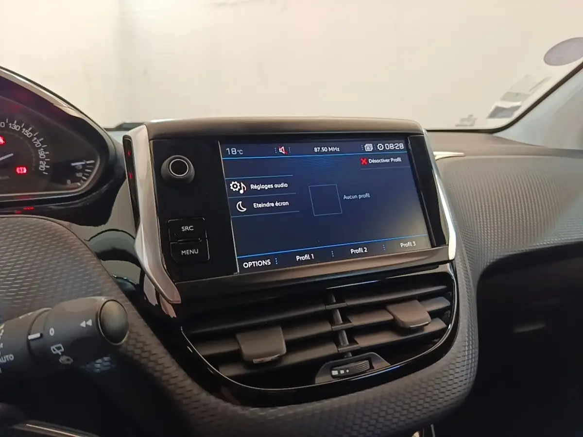 Vue rapprochée du tableau de bord de la Peugeot 208 gris clair, avec écran tactile 7 pouces et commandes intégrées.