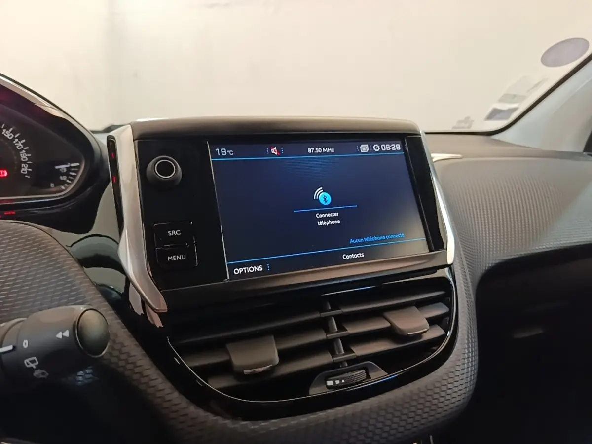 Vue rapprochée du tableau de bord noir et gris d’une Peugeot 208 Puretech 82 Allure avec écran tactile central allumé.