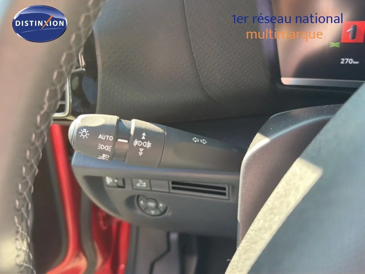 Gros plan sur la commande des feux et clignotants à gauche du volant d'une Citroën C4 X rouge Elixir Metal.