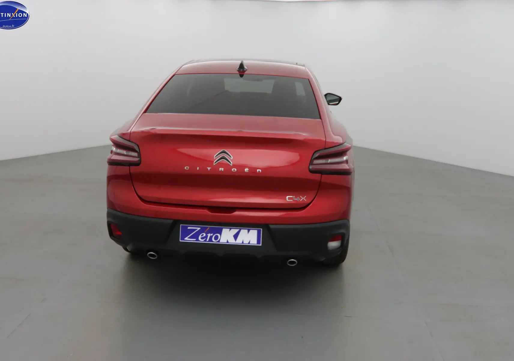 Vue arrière d'une Citroën C4 X rouge Elixir Métal avec feux LED et double sortie d'échappement visible.