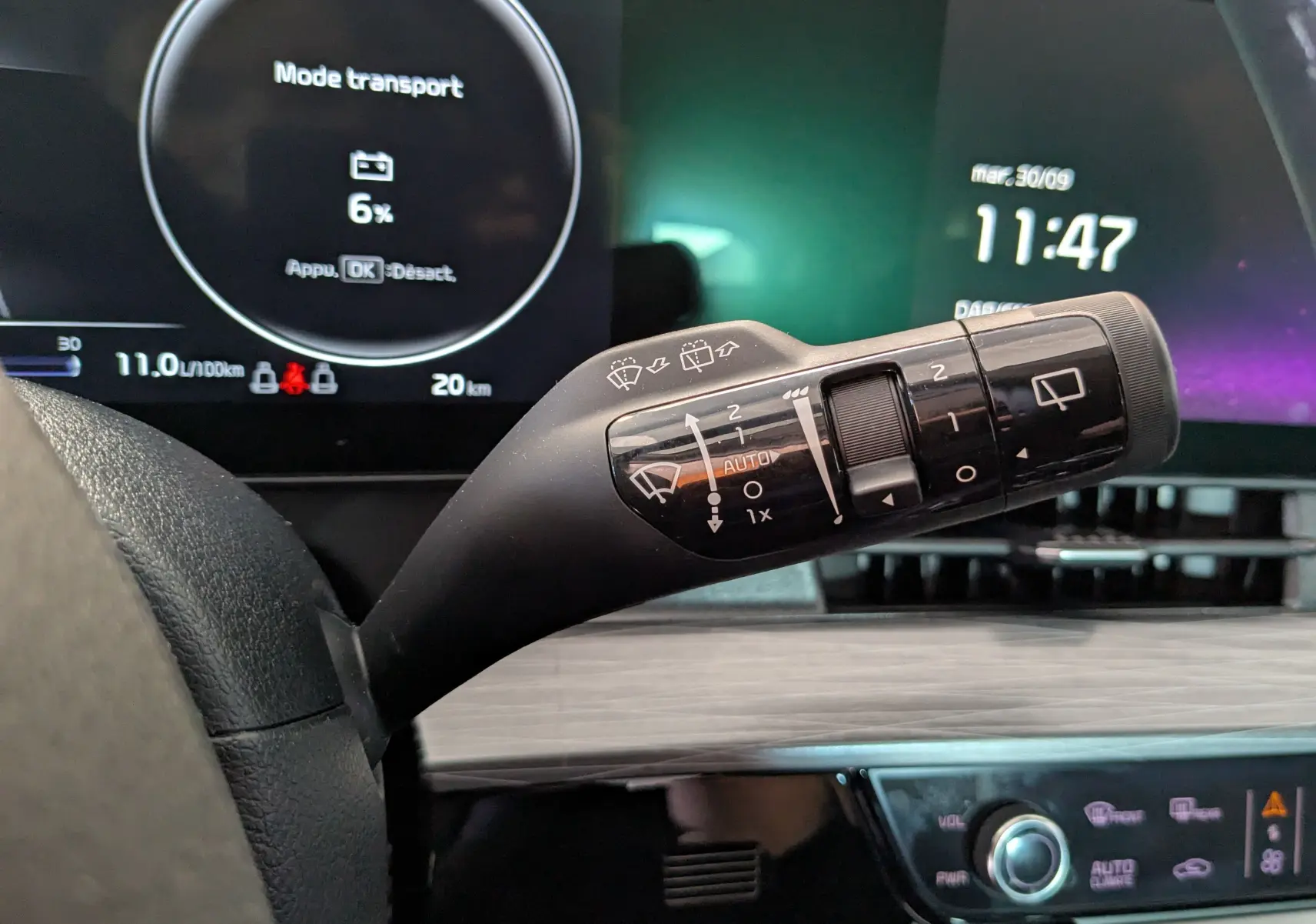 Gros plan sur la commande des essuie-glaces dans l'habitacle du Kia Sportage gris eclipse, tableau de bord numérique en arrière-plan.