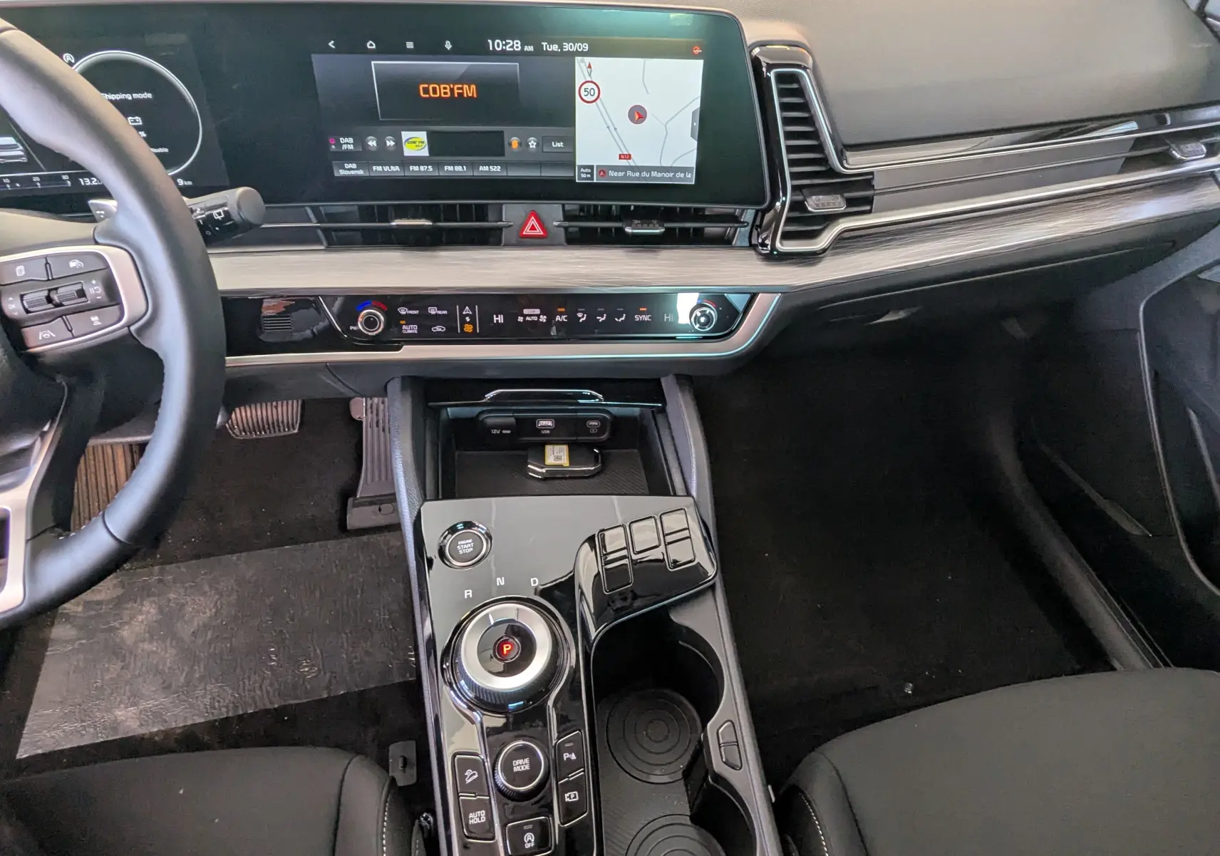 Intérieur du Kia Sportage MY25 gris eclipse, vue du tableau de bord et console centrale avec écran tactile et commandes modernes.