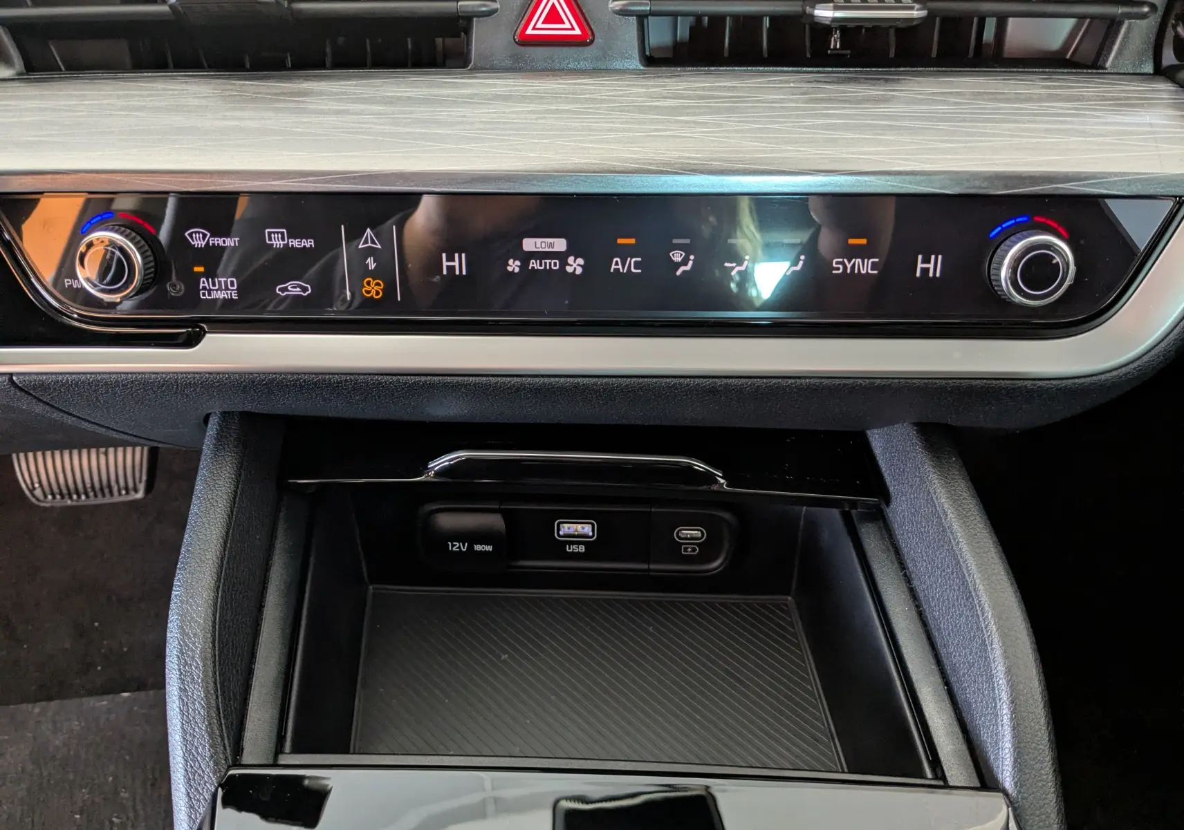 Tableau de bord du Kia Sportage MY25 gris eclipse montrant la console centrale avec commandes climatisation et ports USB.