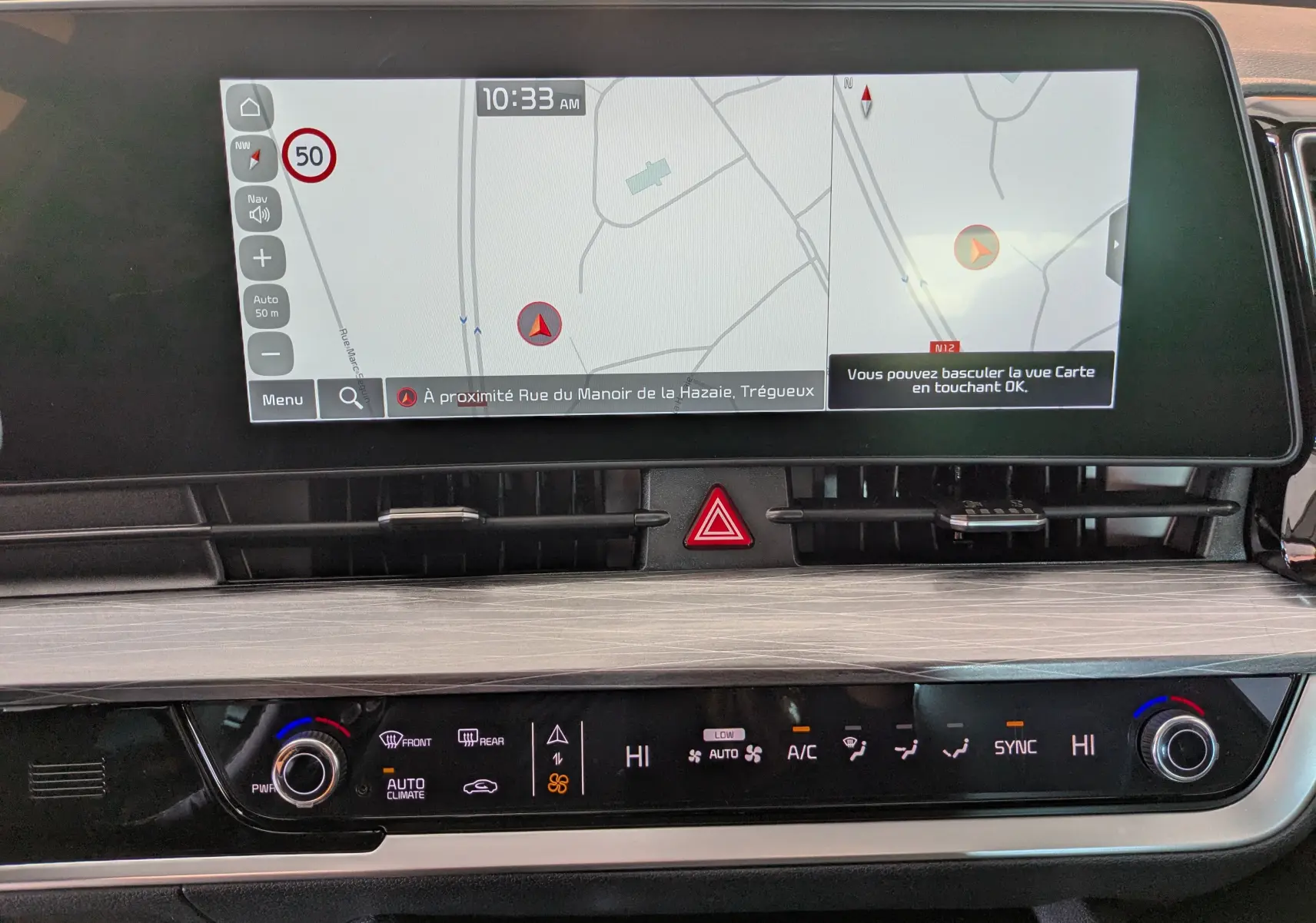 Écran tactile de navigation 12,3 pouces et commandes de climatisation automatique bizone dans le tableau de bord du Kia Sportage gris eclipse.