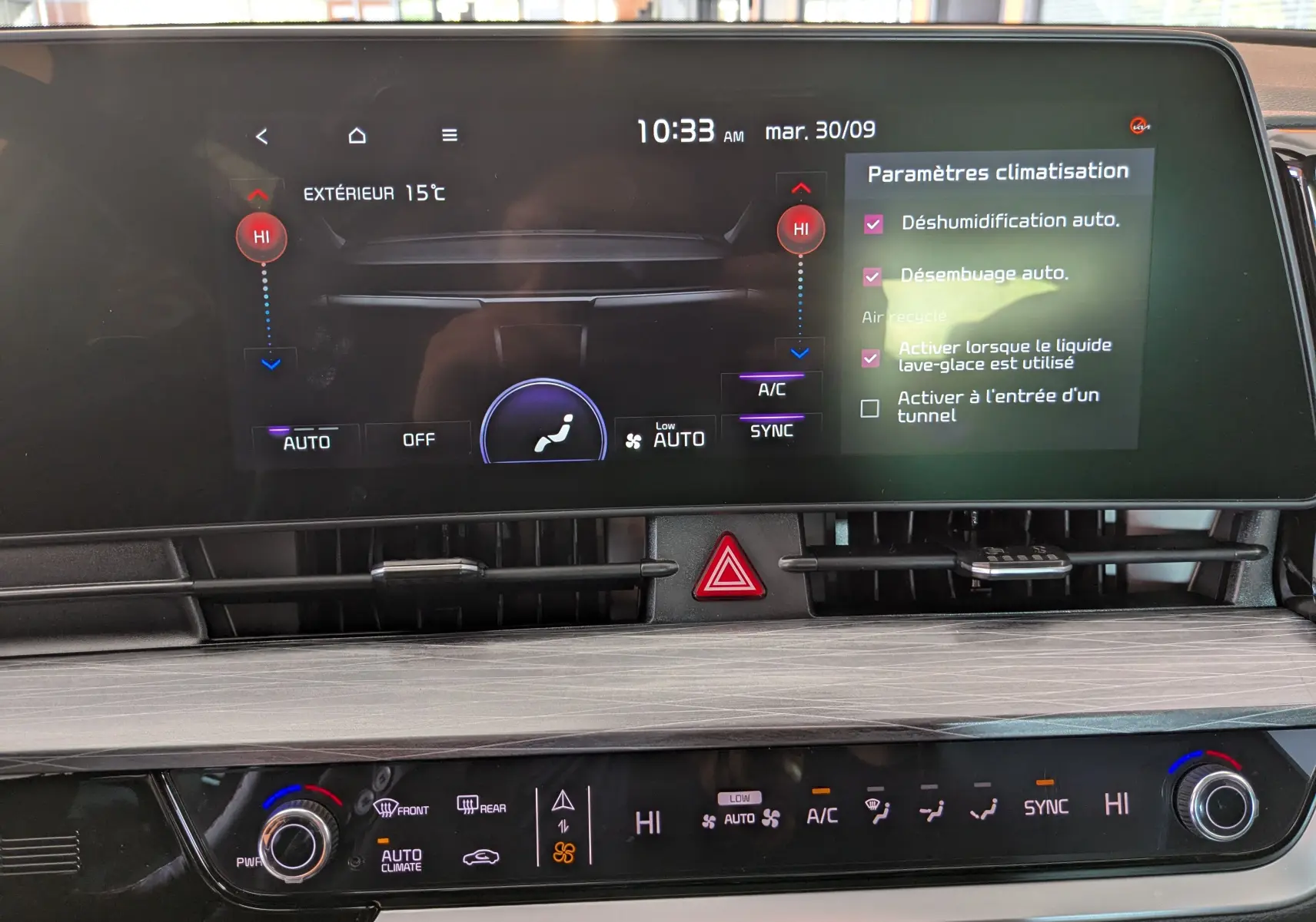 Écran tactile central et commandes de climatisation automatique du tableau de bord du Kia Sportage gris eclipse 2025.