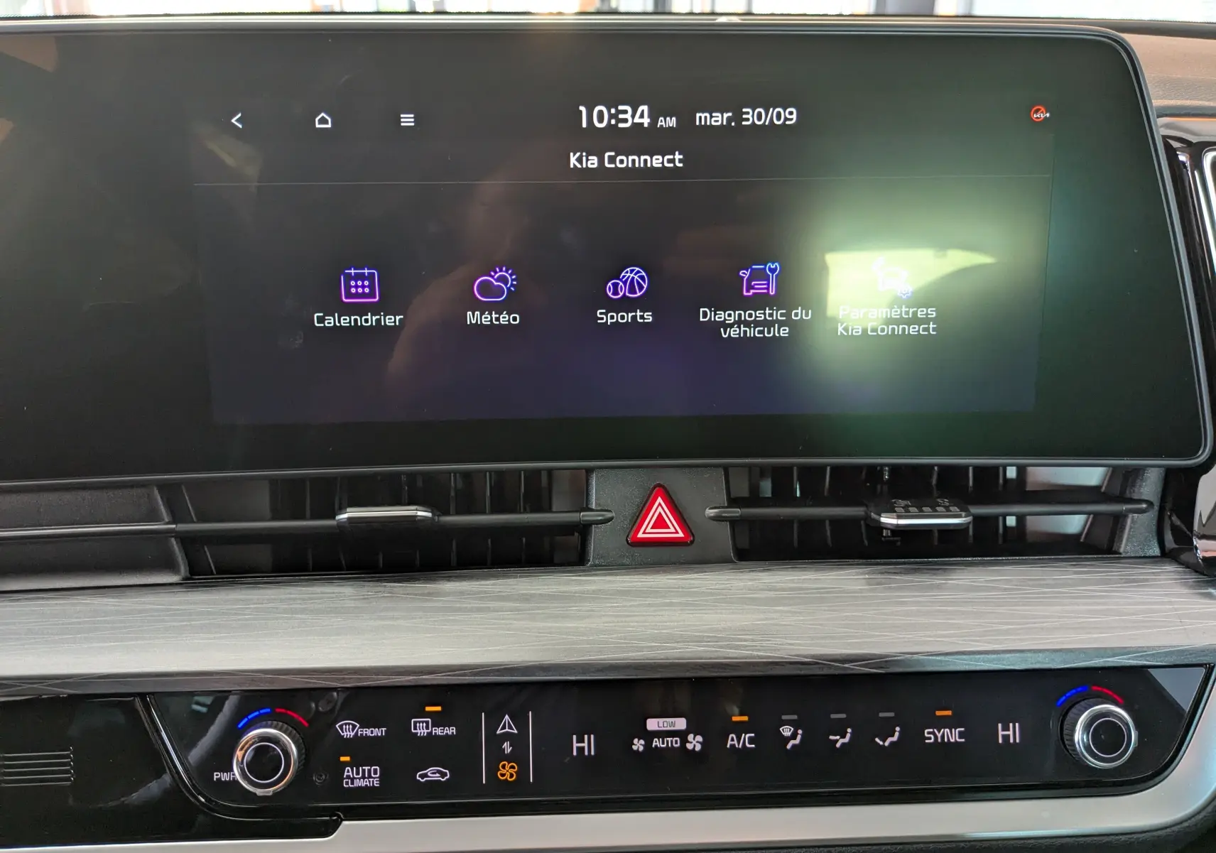 Vue rapprochée de l’écran tactile central et de la console de climatisation du Kia Sportage gris eclipse 2025.