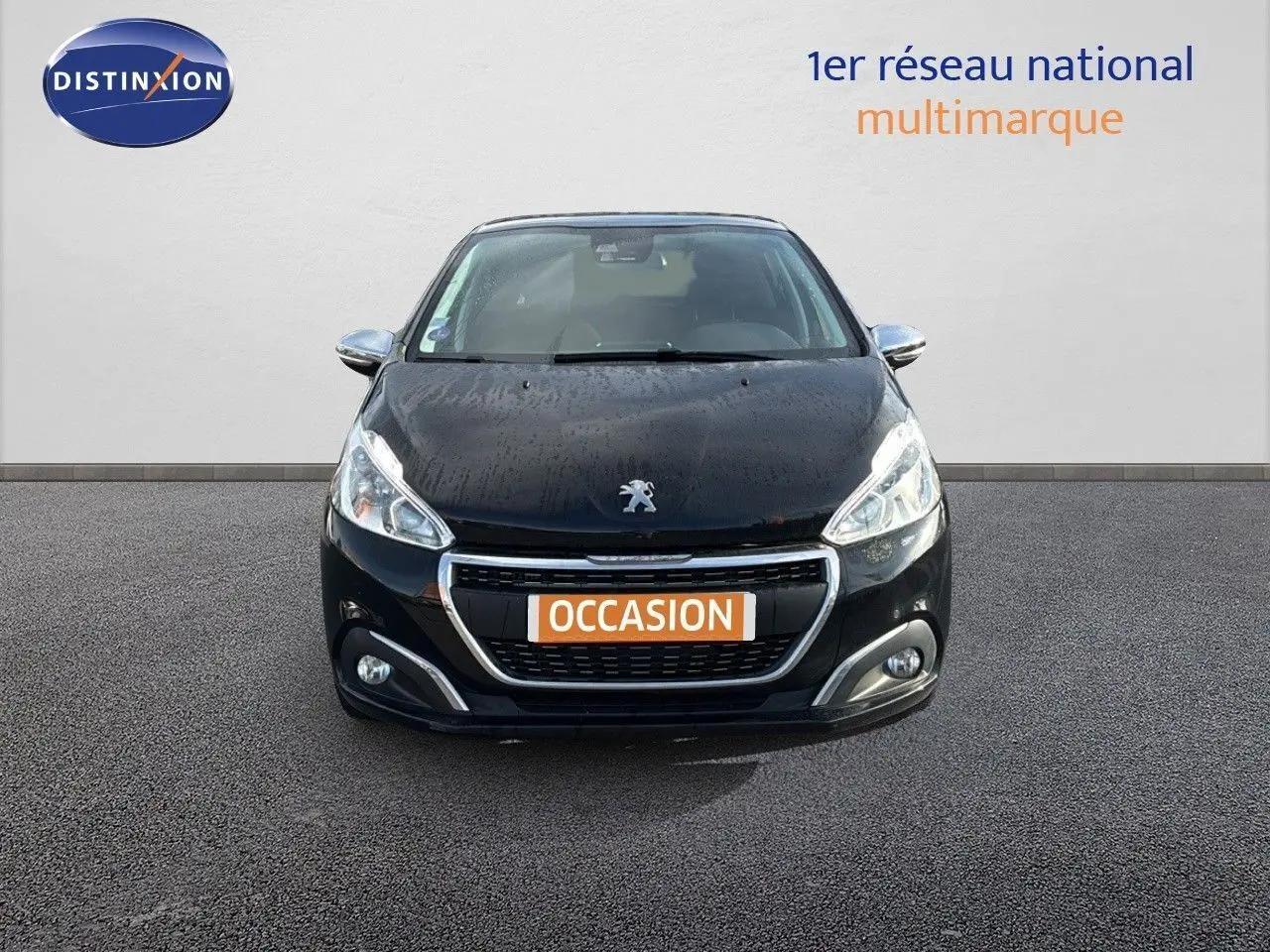 Vue frontale d'une Peugeot 208 noire perle métal de 2019 avec plaque "OCCASION" sur un fond neutre.