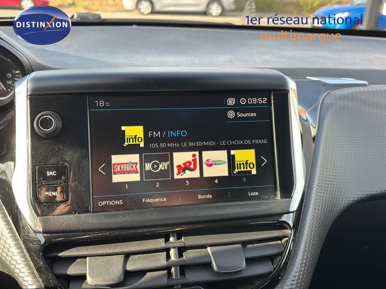 Écran tactile central du tableau de bord d'une Peugeot 208 2019 affichant les stations radio FM, avec commandes autour.