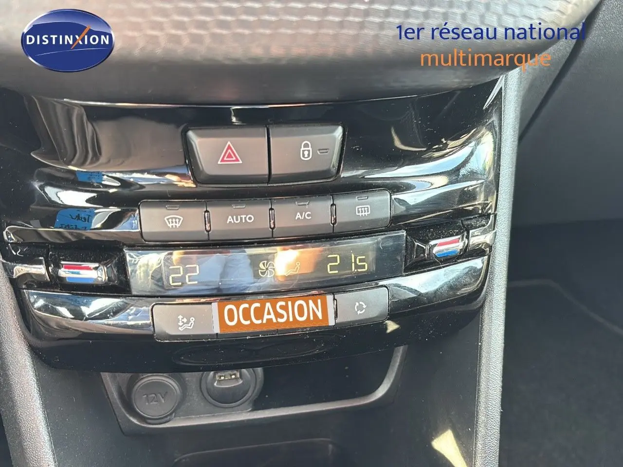 Console centrale en gros plan de la Peugeot 208 noire perle métal, montrant les commandes de climatisation digitale.