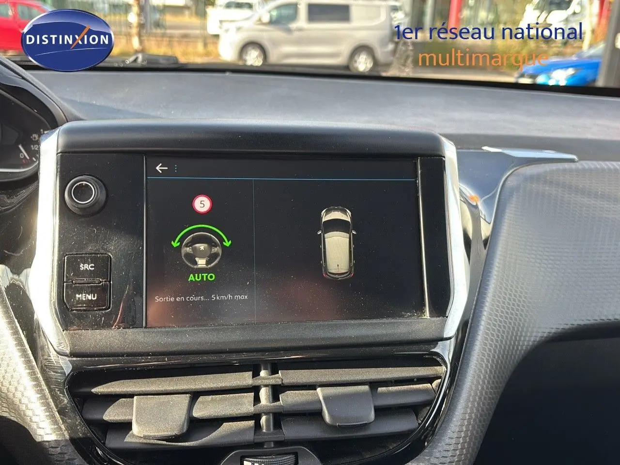 Écran central tactile de la Peugeot 208 2019 affichant l'assistance au stationnement en mode automatique.