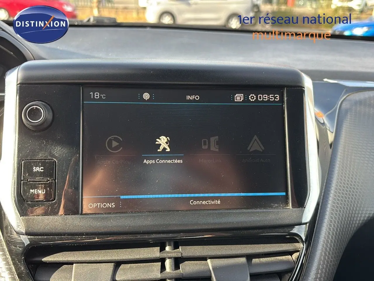 Écran tactile central de la Peugeot 208 noire perle métal, affichant les options de connectivité, vue intérieure frontale.