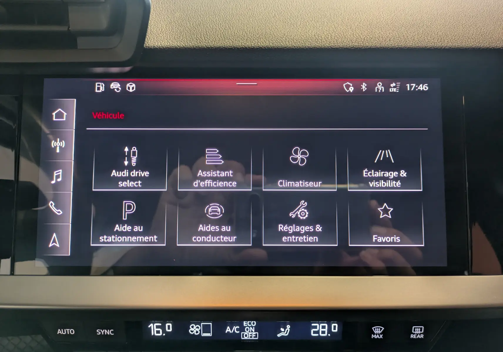 Écran tactile central de l'Audi A3 Sportback 2021 affichant les options d'assistance et climatisation, intérieur noir.
