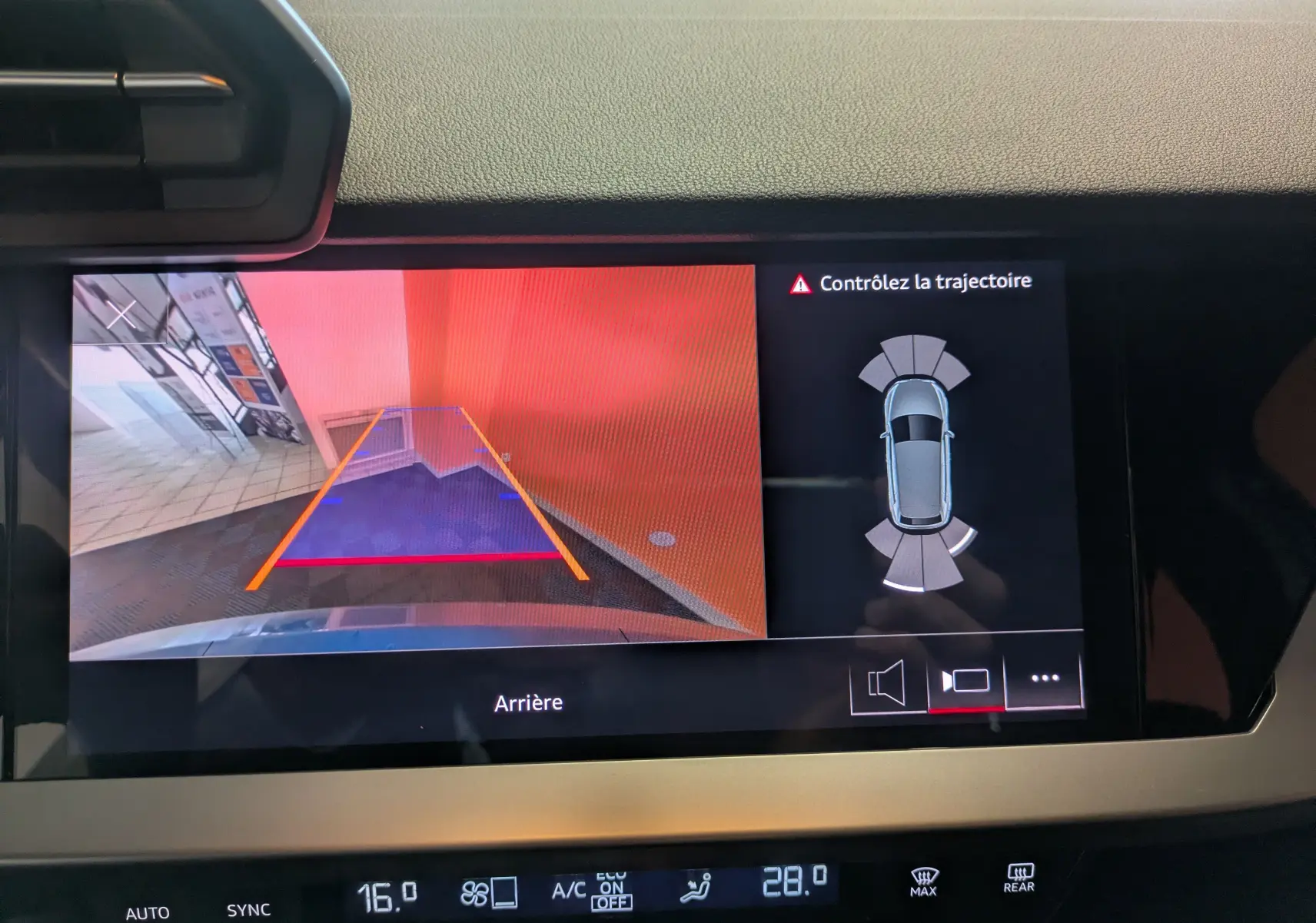 Écran multimédia montrant la caméra de recul et l'aide au stationnement de l'Audi A3 Sportback bleu Atollblau.