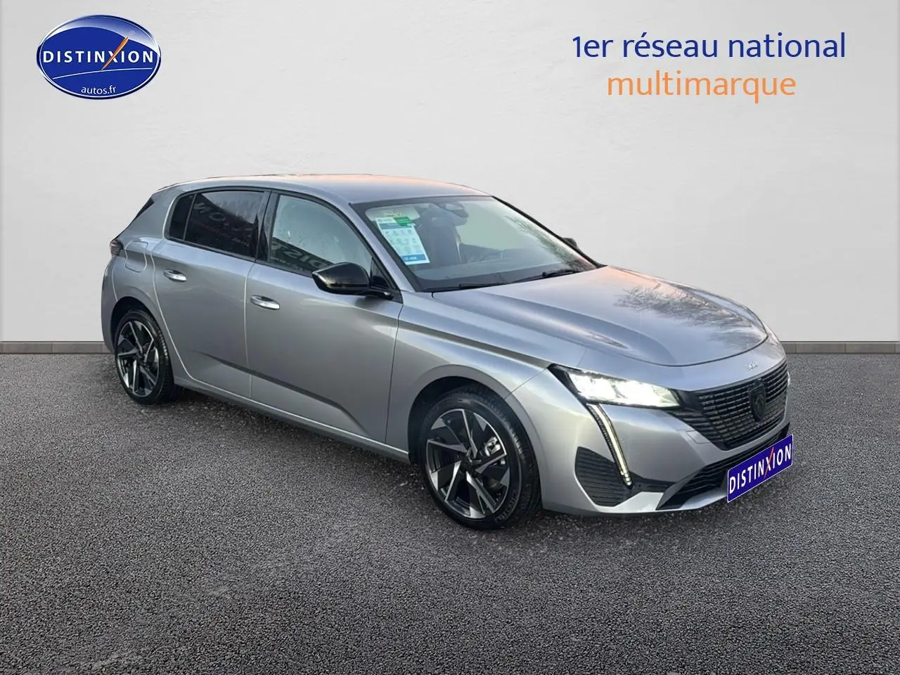 PEUGEOT 308 gris artense en 3/4 avant droit avec phares LED allumés et jantes alu distinctives.