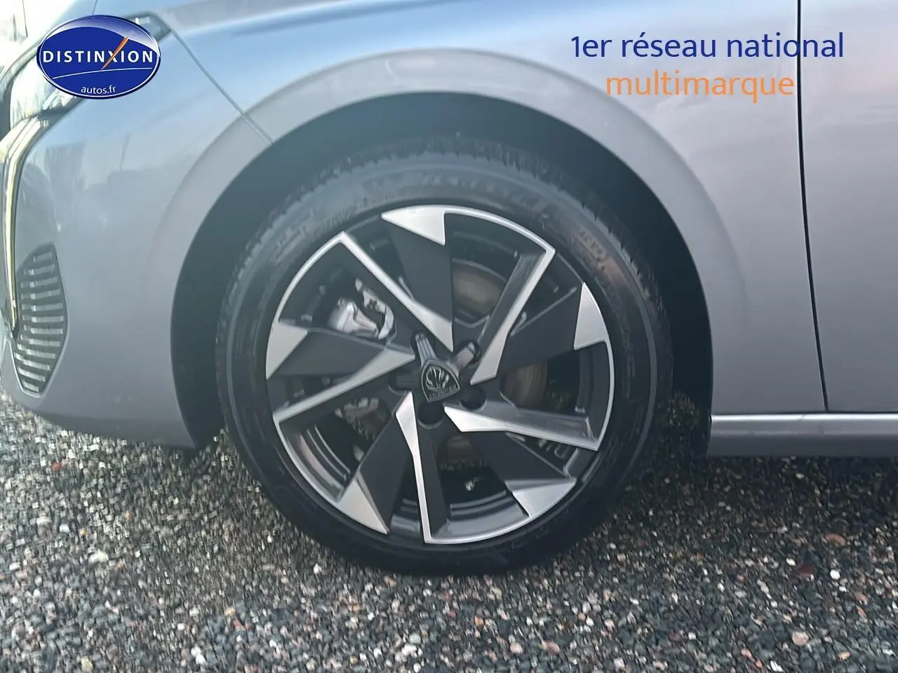 Gros plan sur la roue avant gauche avec jante alu bicolore du Peugeot 308 gris artense 2025.