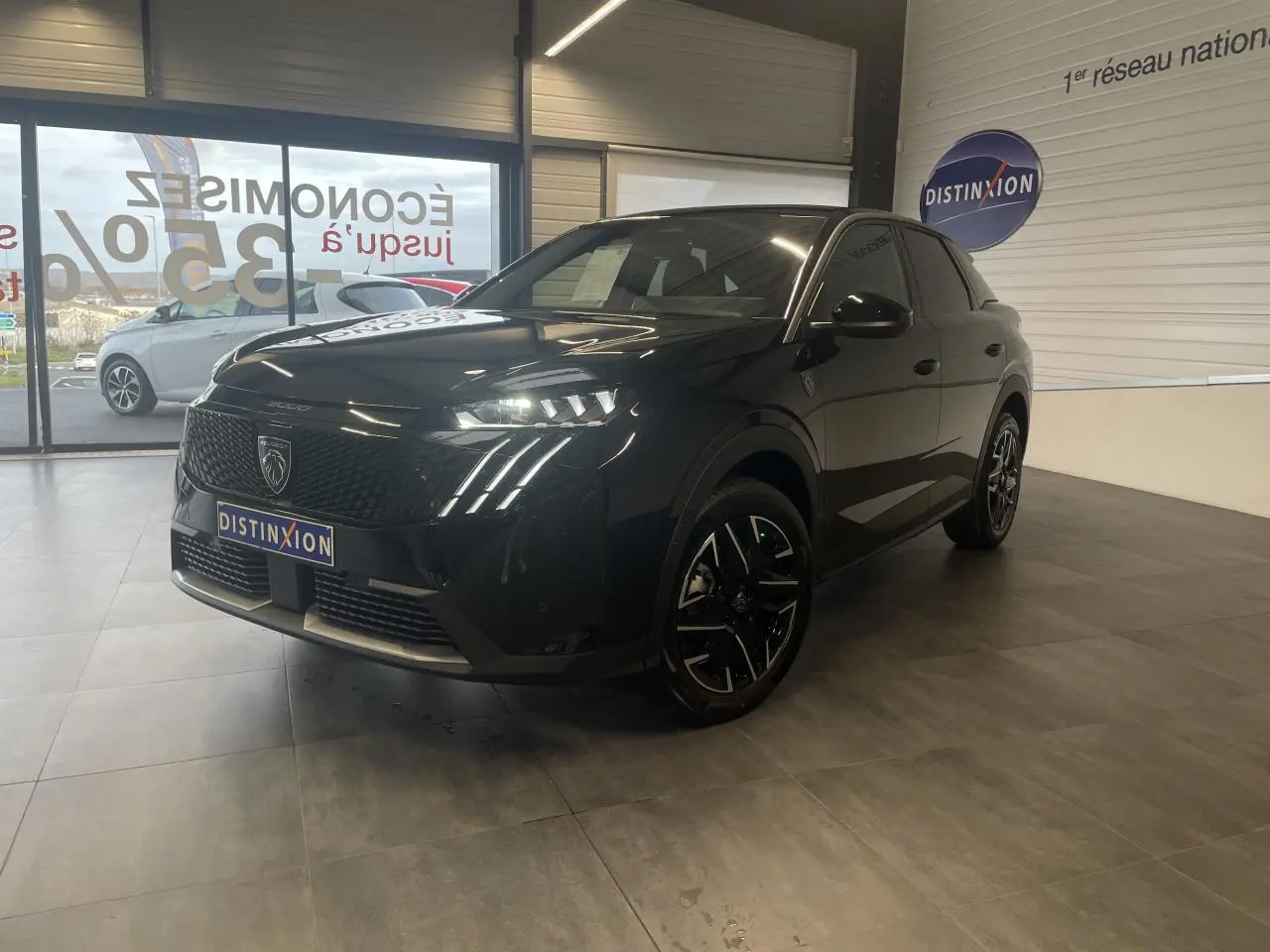 Peugeot 3008 GT noir métallisé, vue 3/4 avant droit en intérieur avec feux LED griffes allumés.