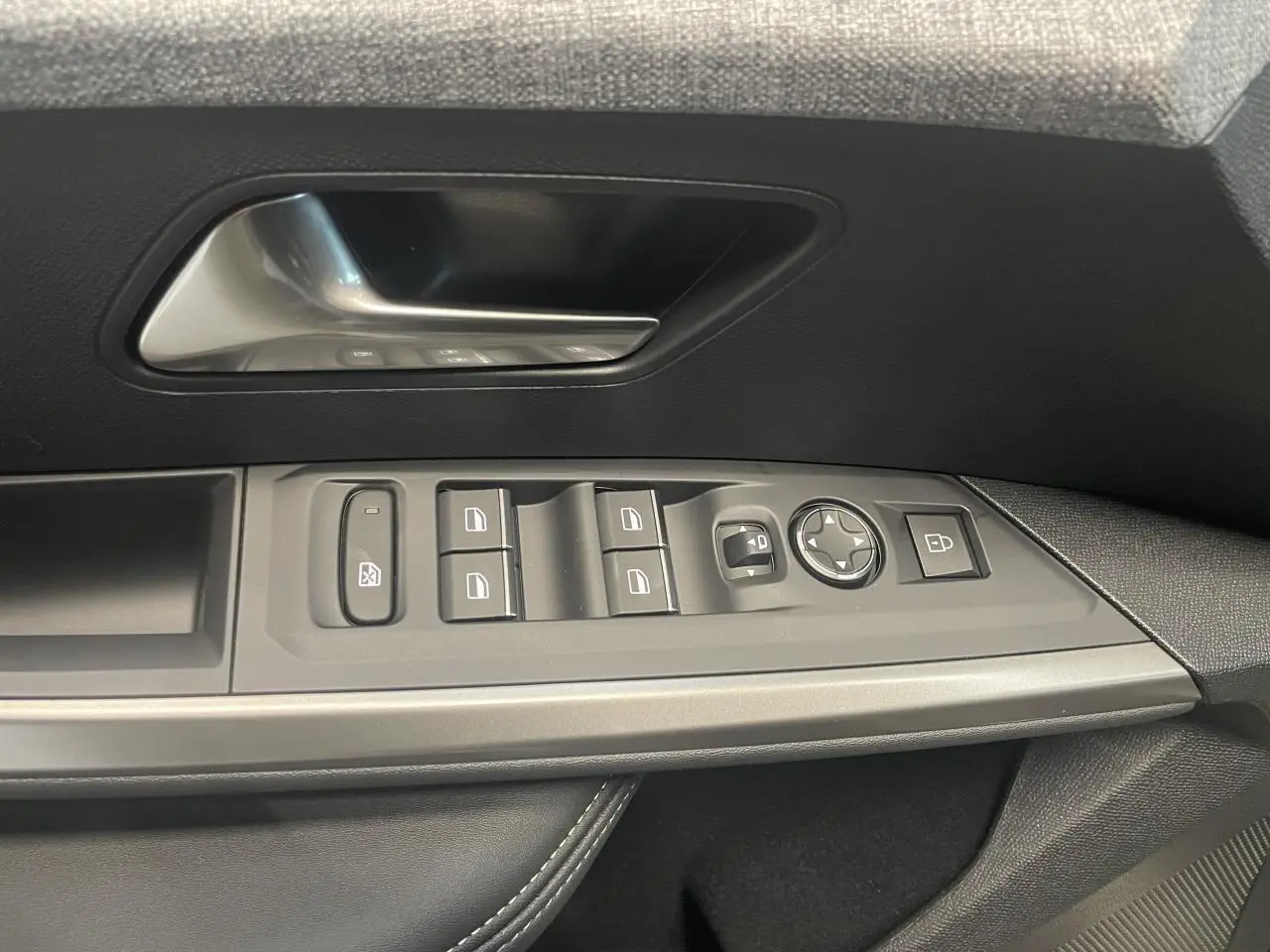 Vue rapprochée des commandes de lève-vitres et rétroviseurs sur la porte avant gauche du Peugeot 3008 noir métallisé 2025 GT.