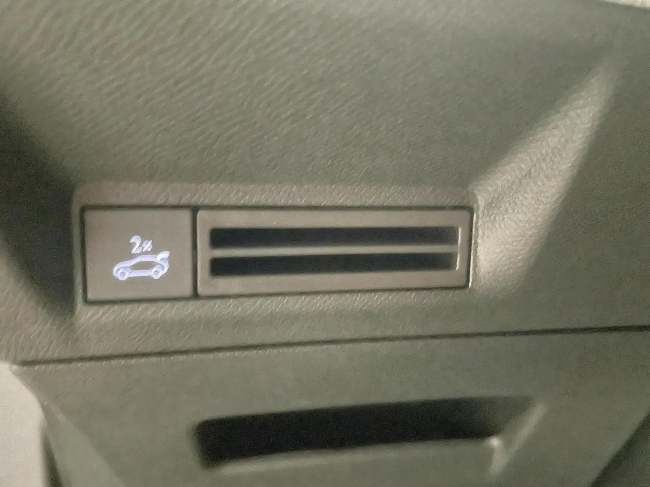 Détail du bouton d'ouverture du hayon électrique sur la console centrale du Peugeot 3008 noir métallisé 2025.