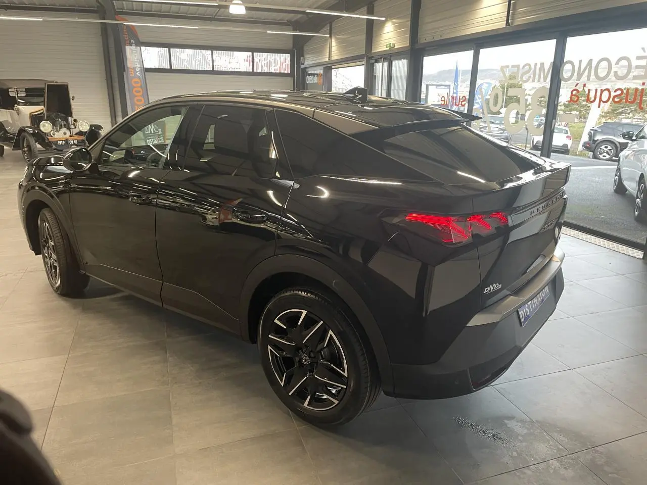 Peugeot 3008 GT noir métallisé vue 3/4 arrière droit en intérieur avec feux arrière à griffes LED.
