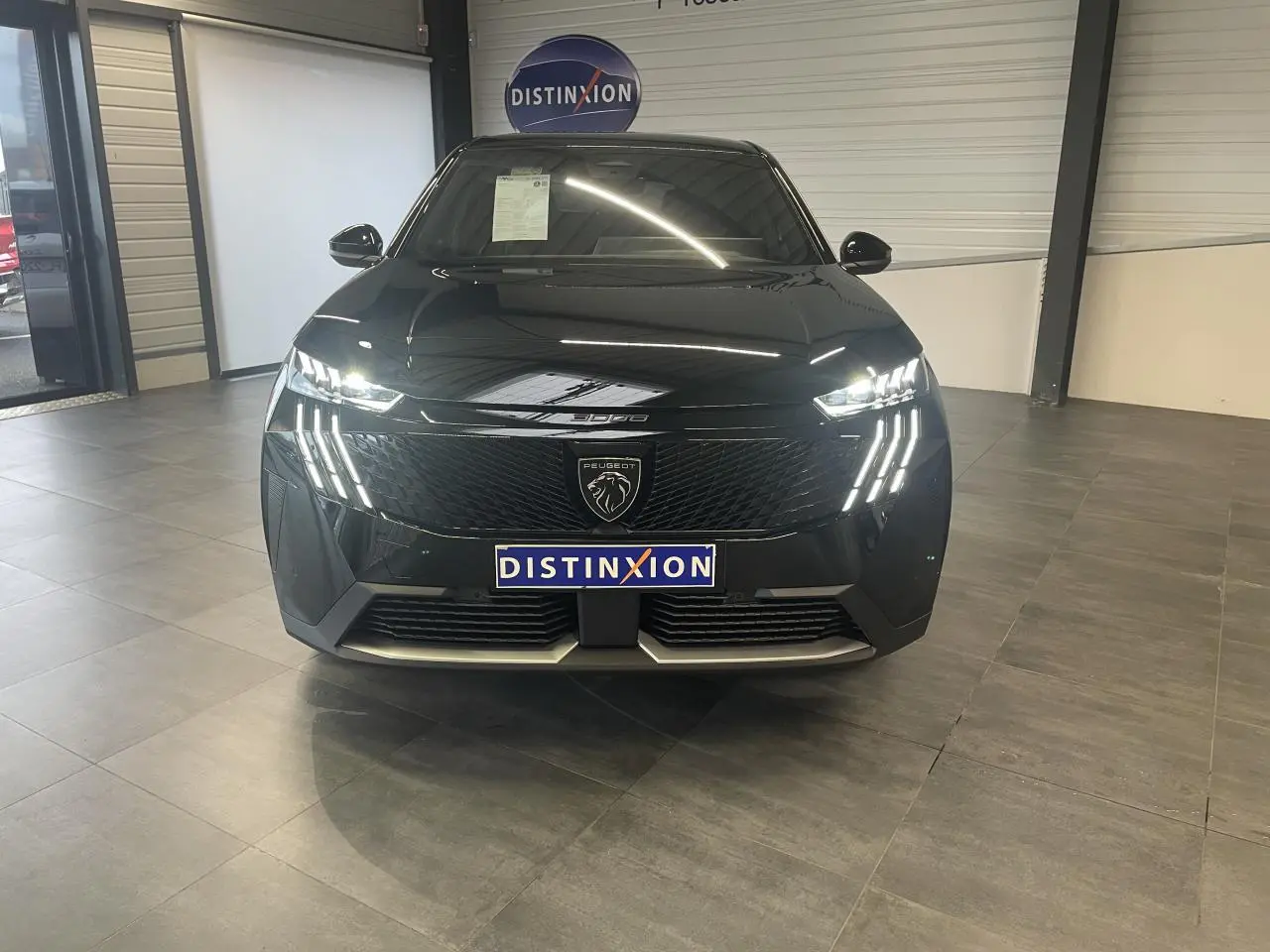 Vue frontale d’un Peugeot 3008 GT noir métallisé avec feux LED griffes et calandre noire laquée en showroom.