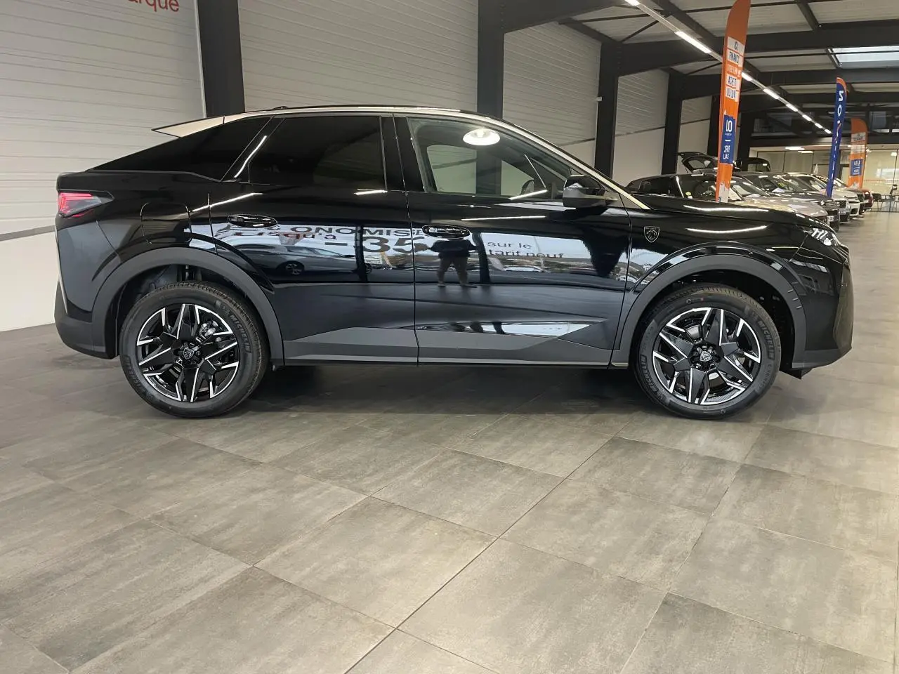 Peugeot 3008 GT noir métallisé vue de profil côté gauche en intérieur avec jantes alliage 19 pouces.