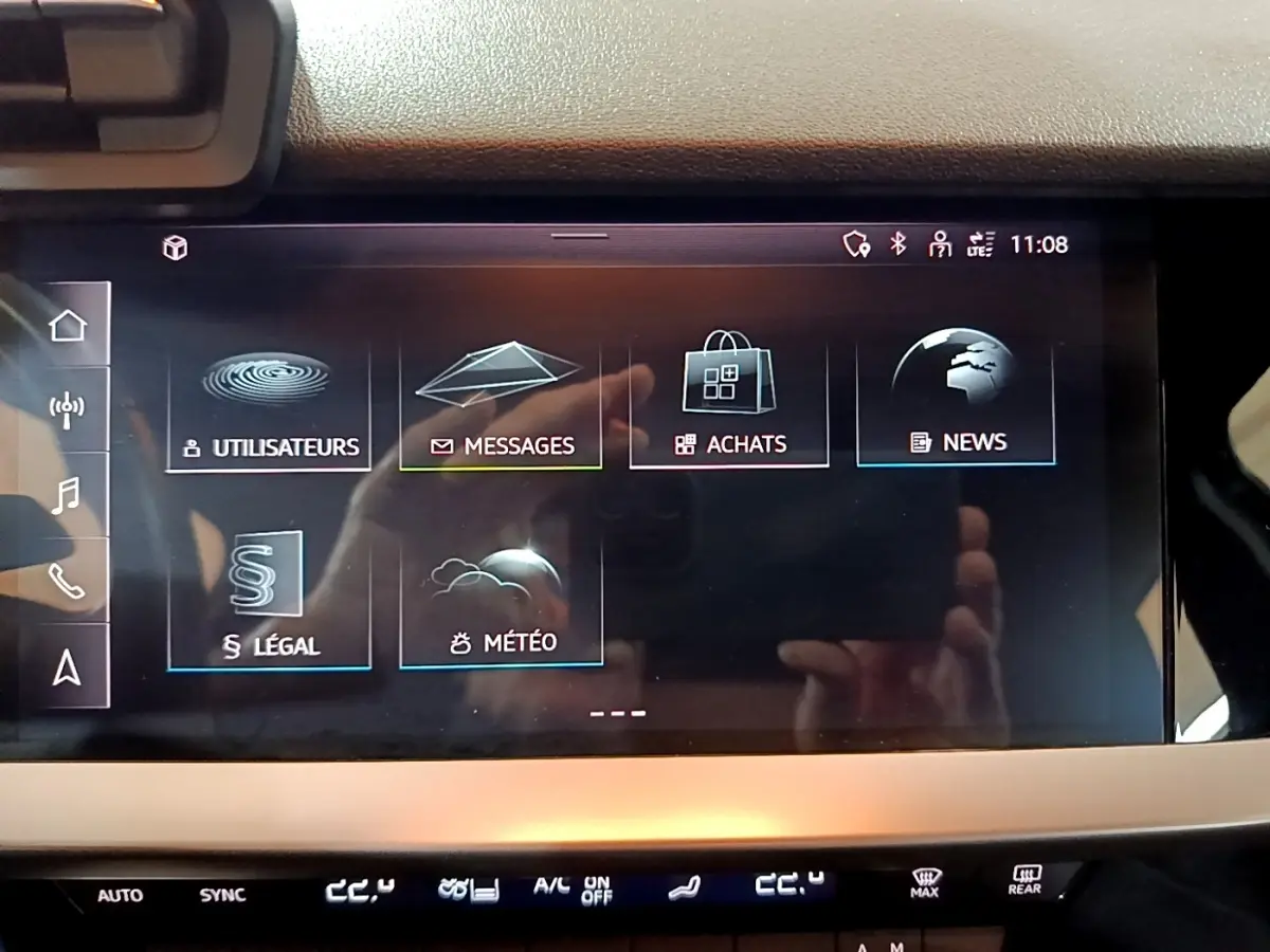 Écran tactile central de l’Audi A3 gris foncé, affichant le menu principal avec options messages et météo.