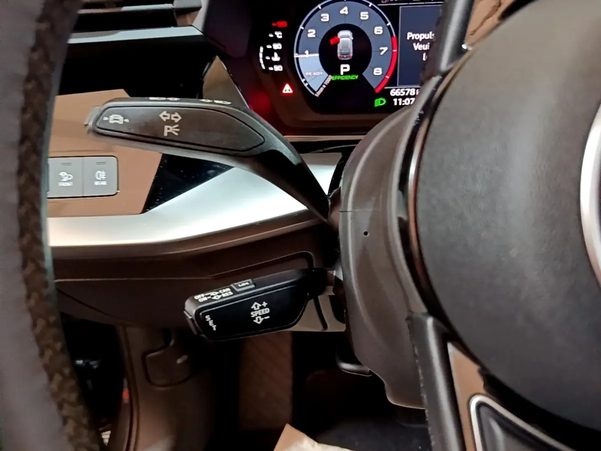 Gros plan sur le volant cuir et les commandes au volant de l'Audi A3 35 TFSI 2021, affichage numérique visible.