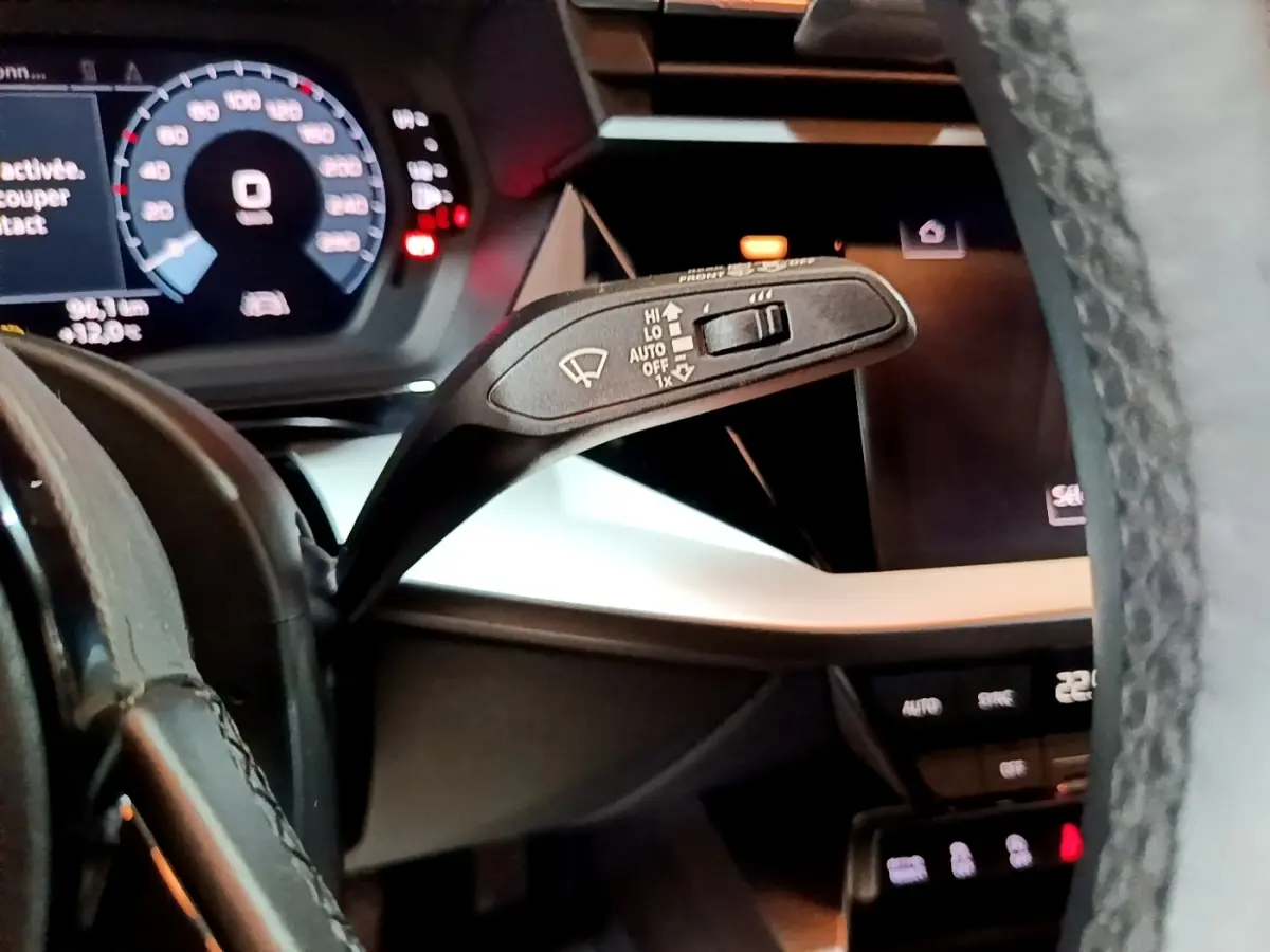 Gros plan sur le commodo d’essuie-glace côté gauche du tableau de bord gris foncé d’une Audi A3 35 TFSI 2021.