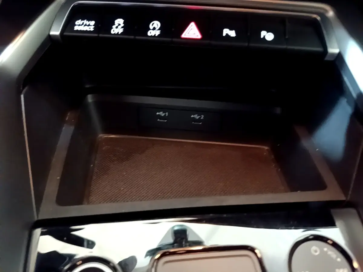 Vue rapprochée de la console centrale de l'Audi A3 gris foncé, avec boutons de contrôle et ports USB visibles.