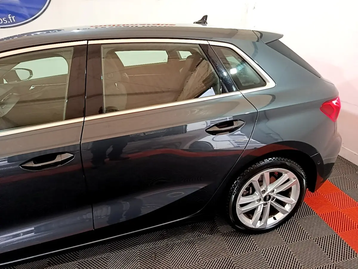 Vue latérale droite d'une Audi A3 35 TFSI gris foncé, mettant en valeur la porte arrière et la roue arrière en alliage.