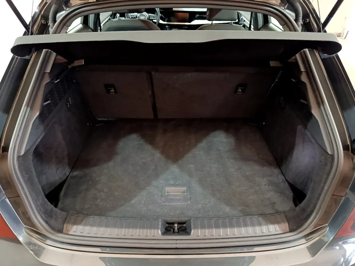Vue arrière ouverte du coffre gris foncé de l'Audi A3 35 TFSI 150 MHEV Business Line, espace de chargement vide et propre.