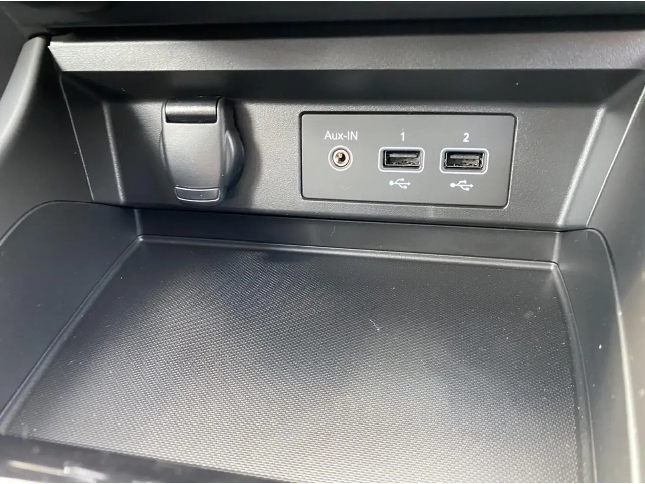 Gros plan sur la console centrale noire du Renault Arkana 2022 avec ports USB et prise Aux-In visibles.