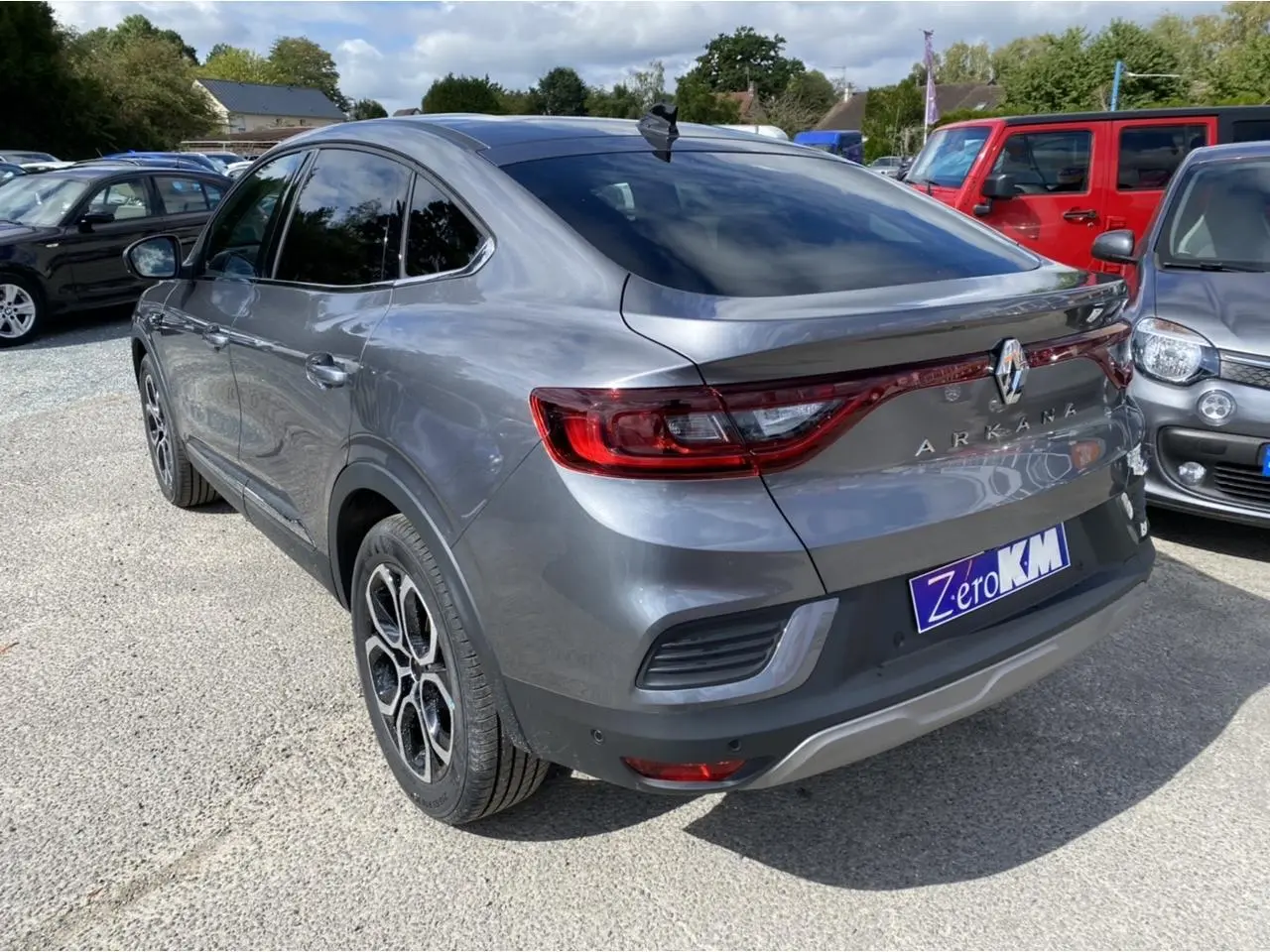 Renault Arkana gris foncé vu en 3/4 arrière droit, avec feux arrière LED et antenne aileron de requin.