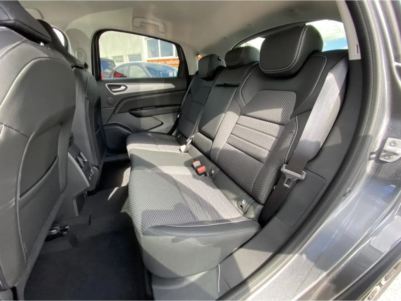 Vue intérieure côté droit des sièges arrière en tissu et cuir noir du Renault Arkana gris foncé 2022.