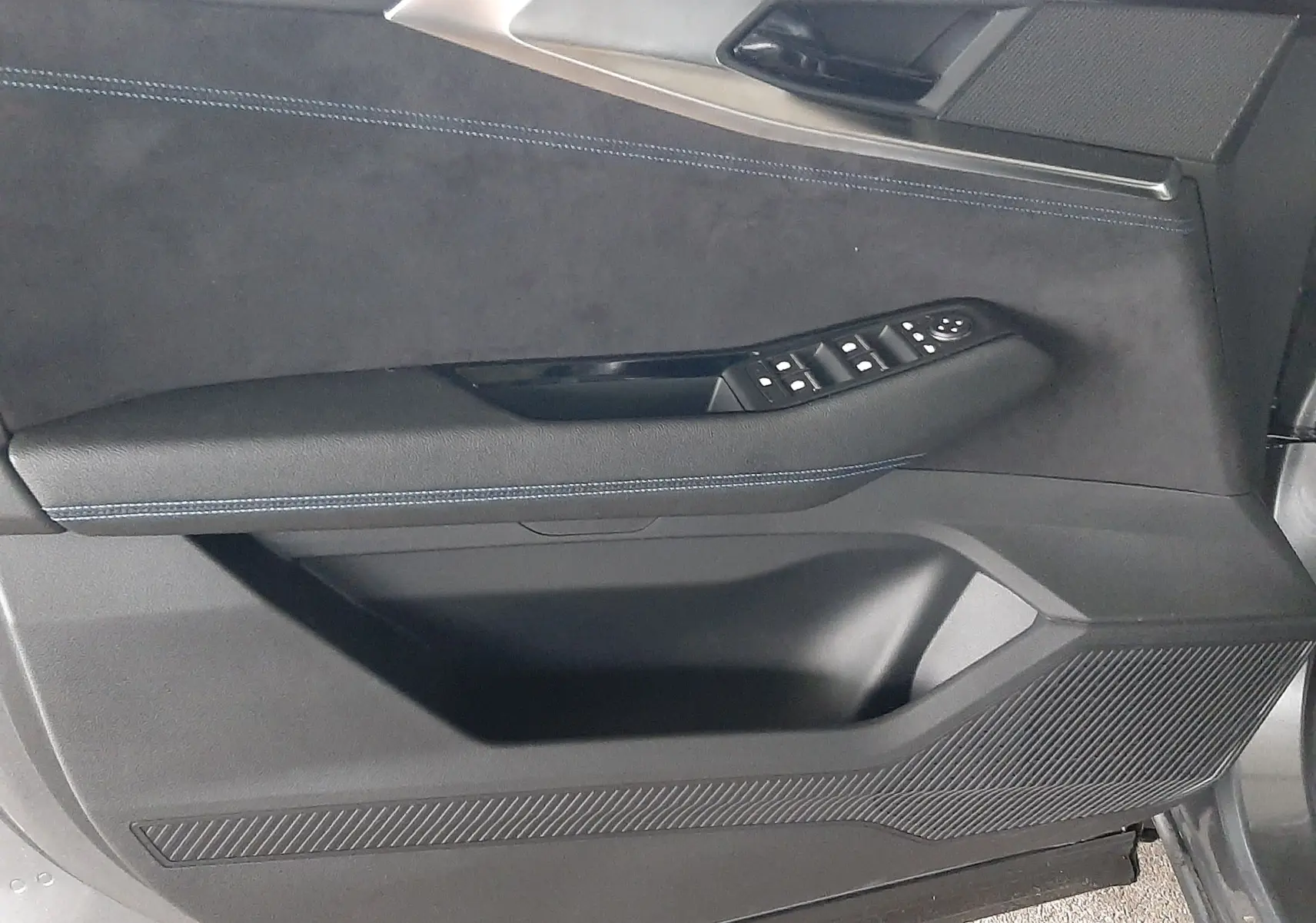 Gros plan sur la porte côté conducteur du Renault Austral 2025, finition intérieure noire avec surpiqûres bleues.