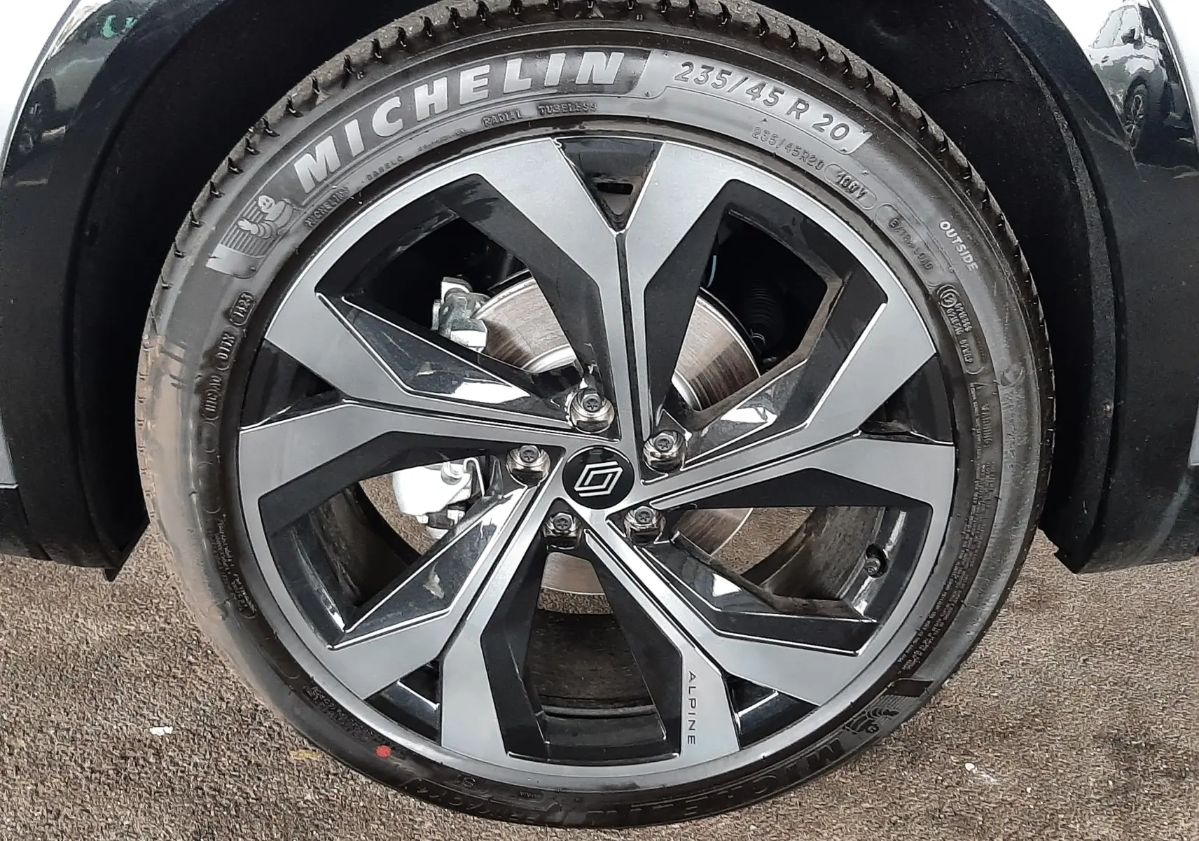 Gros plan sur la roue avant droite du Renault Austral E-Tech gris schiste satin avec jante bi-ton Alpine et pneu Michelin.