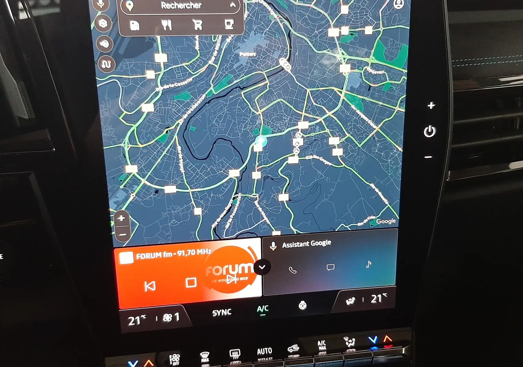 Écran central tactile du Renault Austral E-Tech hybride, affichant la navigation et les commandes climatiques, intérieur noir.