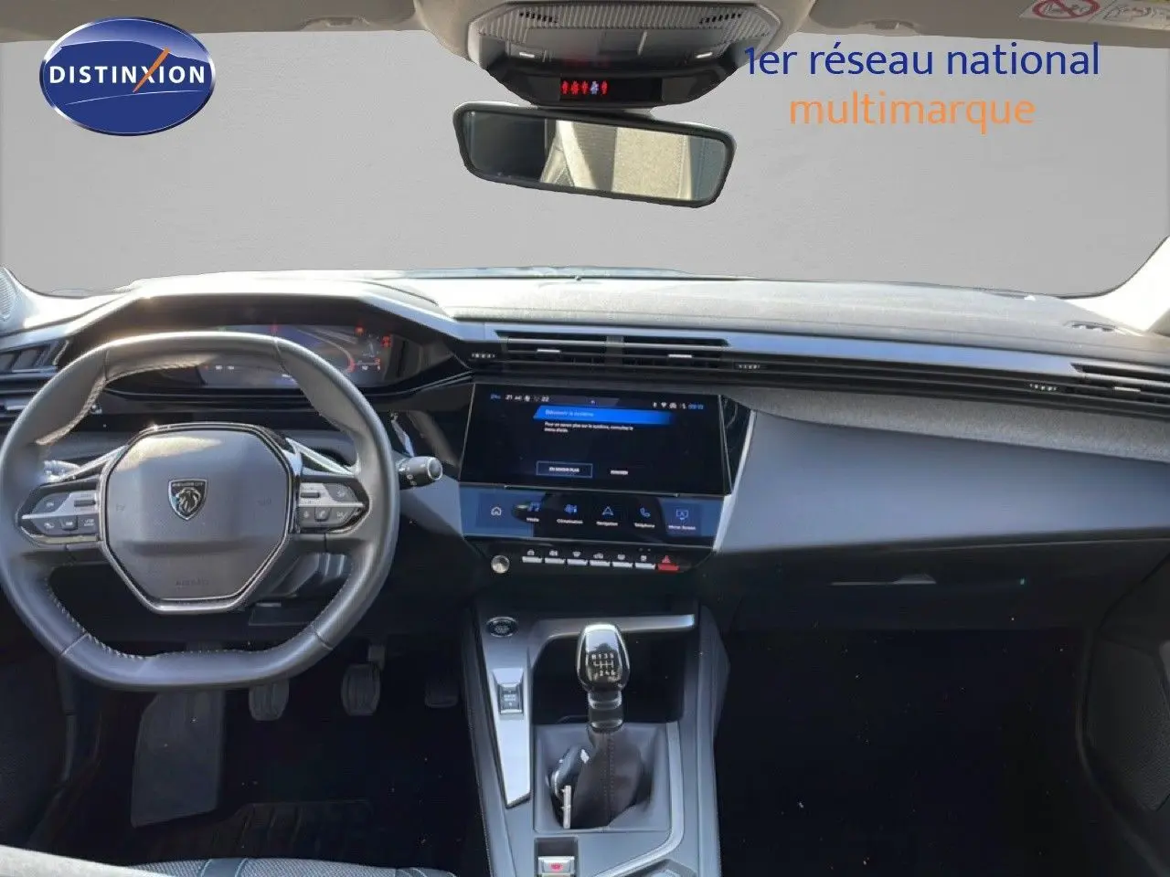 Vue intérieure avant du tableau de bord de la Peugeot 308 2024, volant cuir et écran tactile central noir.